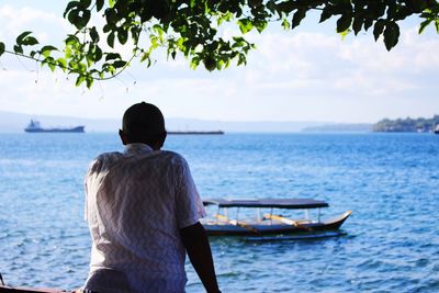 Rear view of couple on sea against sky