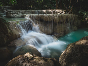 Scenic waterfall flowing stream, turquoise creek in forest.  erawan falls, kanchanaburi, thailand.