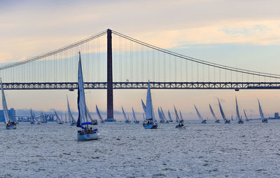 April 25th bridge over boats sailing in sea against sky