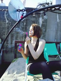 Young woman looking at camera while sitting outdoors