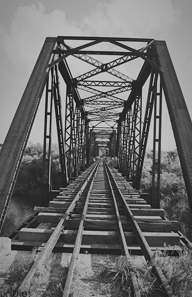 connection, built structure, architecture, bridge - man made structure, the way forward, metal, sky, iron - metal, engineering, transportation, diminishing perspective, outdoors, water, day, cantilever bridge, vanishing point, footpath, cloud - sky, no people, geometric shape, railway bridge, long