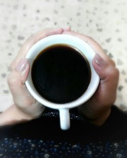 Close-up of hand holding coffee cup