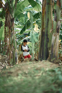 Woman sitting on tree trunk in forest