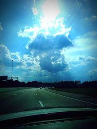 Road against sky seen through car windshield