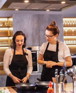 Portrait of young woman preparing food at restaurant