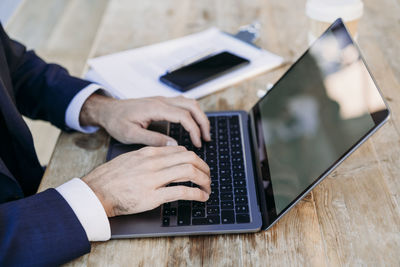 Businessman typing on laptop at table