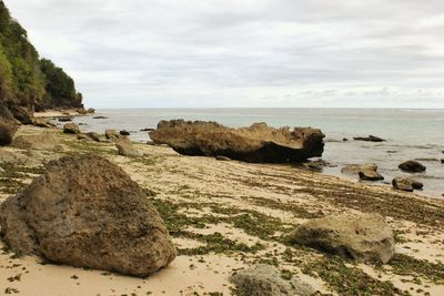 Rocks on beach against sky