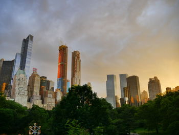 Buildings in city against cloudy sky