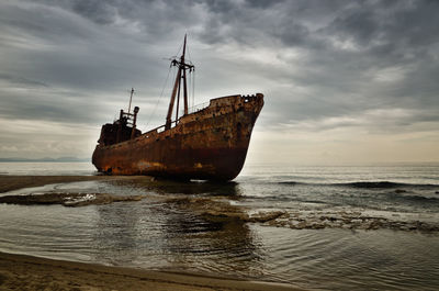 Sailboat on sea shore against sky