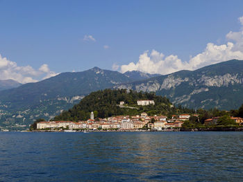 Scenic view of town by sea against sky