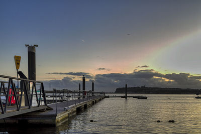 Pier over sea against sky during sunset