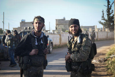 Portrait of smiling soldier standing on road