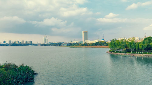 River by buildings against sky