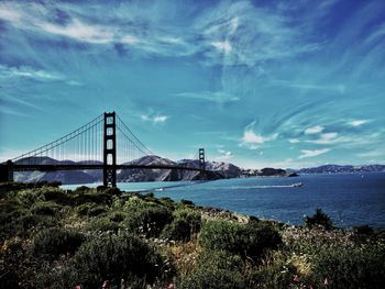 View of suspension bridge against cloudy sky