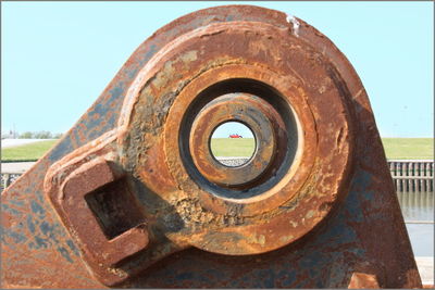 Close-up of old rusty wheel against sky