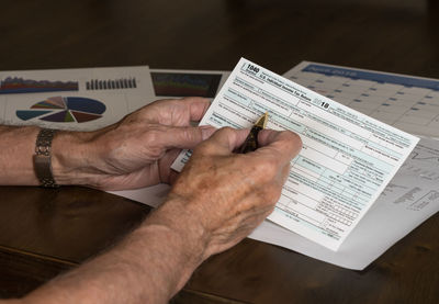 Midsection of man holding book on table