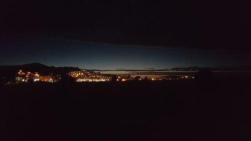 Illuminated cityscape against sky at night