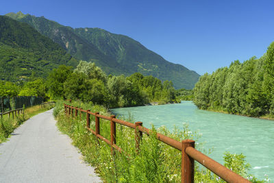 Scenic view of lake and mountains against clear blue sky