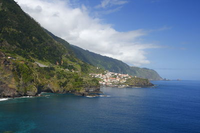 Scenic view of sea and mountains against sky