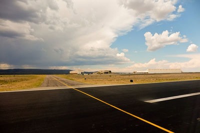 Country road against cloudy sky