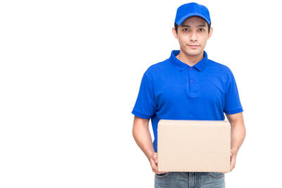 Portrait of salesman with cardboard box standing against white background