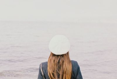 Rear view of woman wearing hat against sea