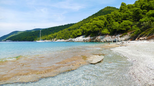 Scenic view of sea and mountains against sky