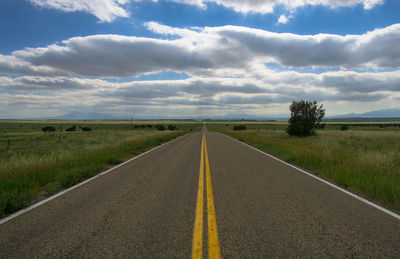 Road by landscape against sky