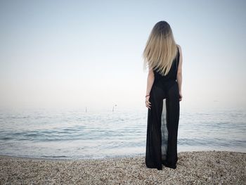 Rear view of woman standing on the shore