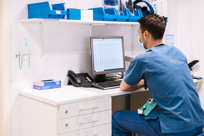 Doctor working on computer at desk in hospital