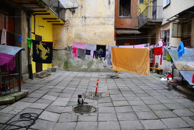 People on footpath amidst buildings in city
