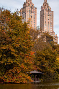 Trees and buildings against sky during autumn
