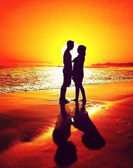 sunset, orange color, sea, silhouette, beach, water, shore, horizon over water, lifestyles, leisure activity, full length, standing, men, scenics, beauty in nature, tranquility, tranquil scene, vacations