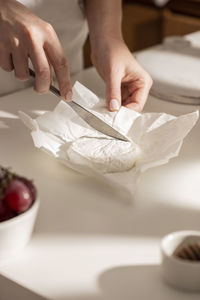 Cropped hand of person preparing food on table