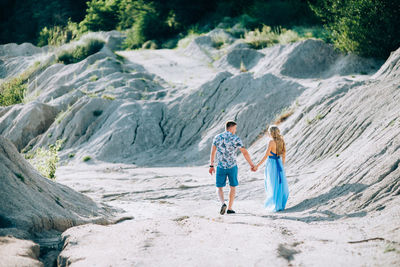 Rear view of people walking on rocks