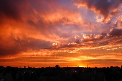 Scenic view of dramatic sky over silhouette landscape