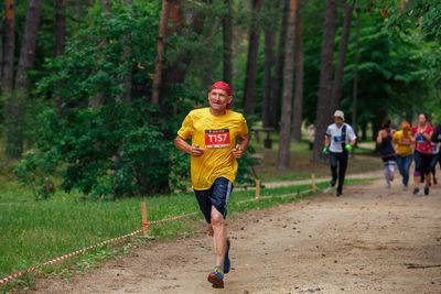 Full length of man running on road in forest