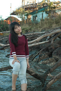 Portrait of beautiful woman standing against trees