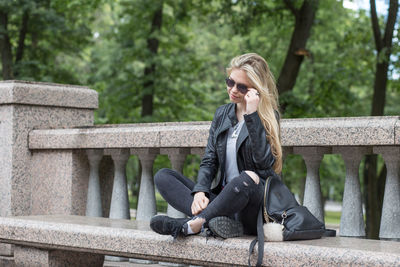 Woman sitting on railing