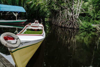 Boats moored in lake at forest