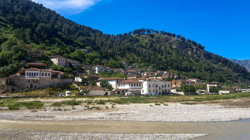 Buildings by town against blue sky