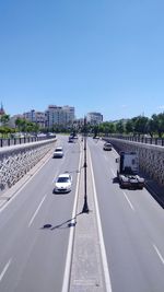 Cars on road against sky in city