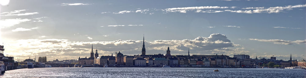 Panoramic view of buildings against cloudy sky