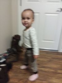 Cute baby girl on hardwood floor at home