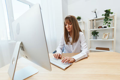 Young woman using laptop on table