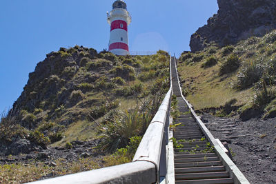 Lighthouse amidst plants against sky