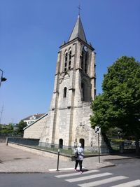 Full length of woman crossing road towards church in city