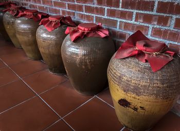 High angle view of covered metallic urns on tiled floor