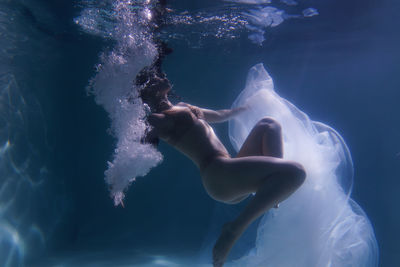 Rear view of woman swimming in sea