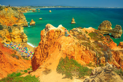 High angle view of woman sitting on rock against sea